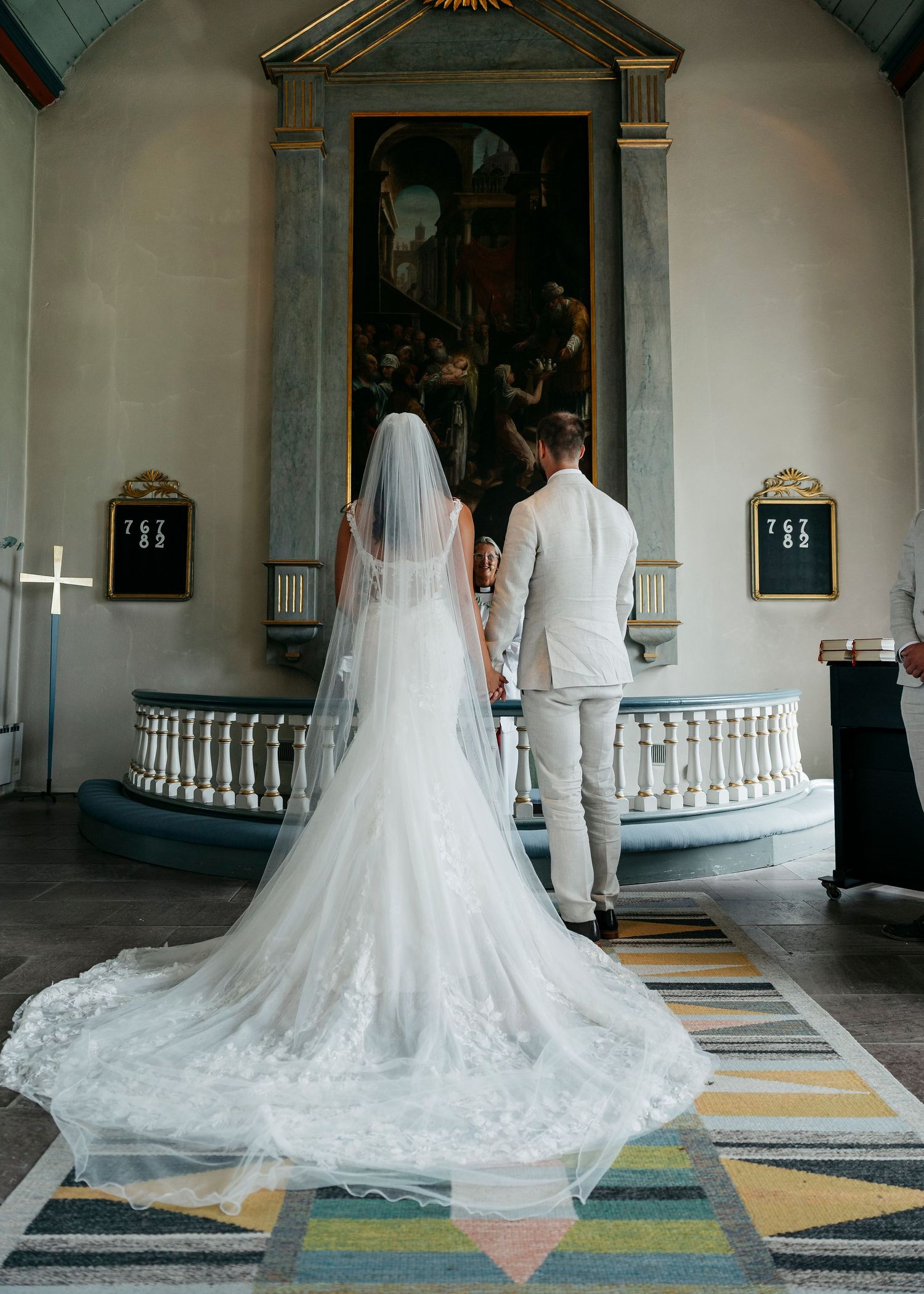 Wedding ceremony in a traditional church interior with white balustrades and ornate decor.
