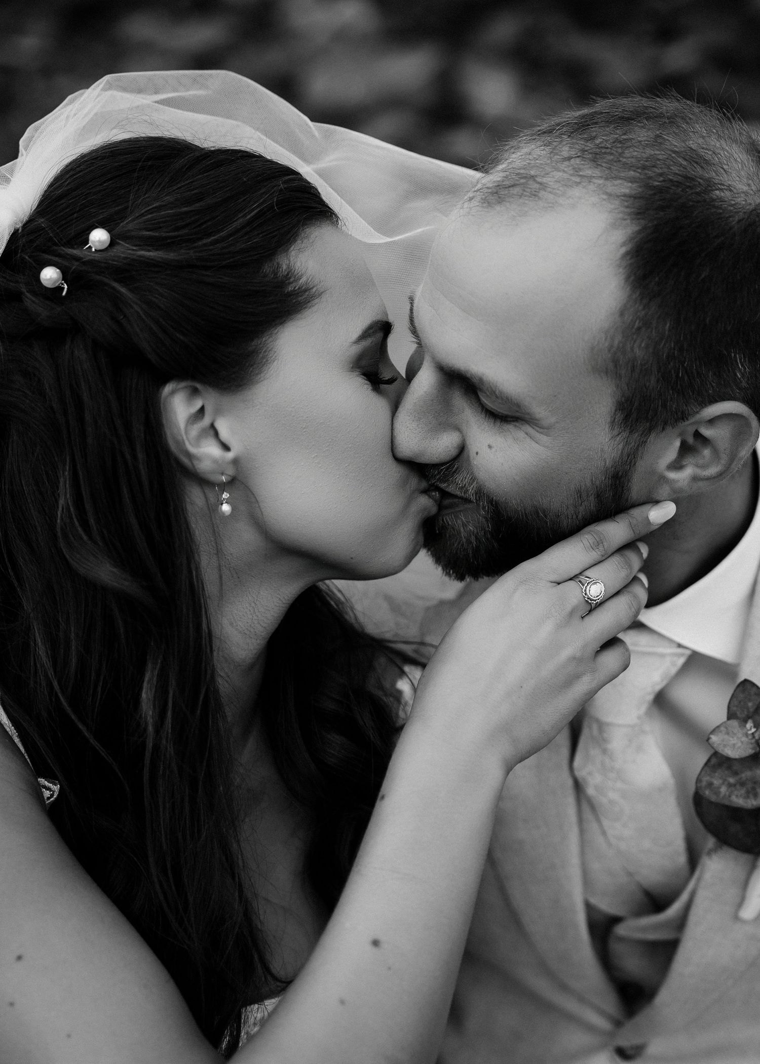 Intimate black and white portrait series of newlyweds sharing tender kisses.