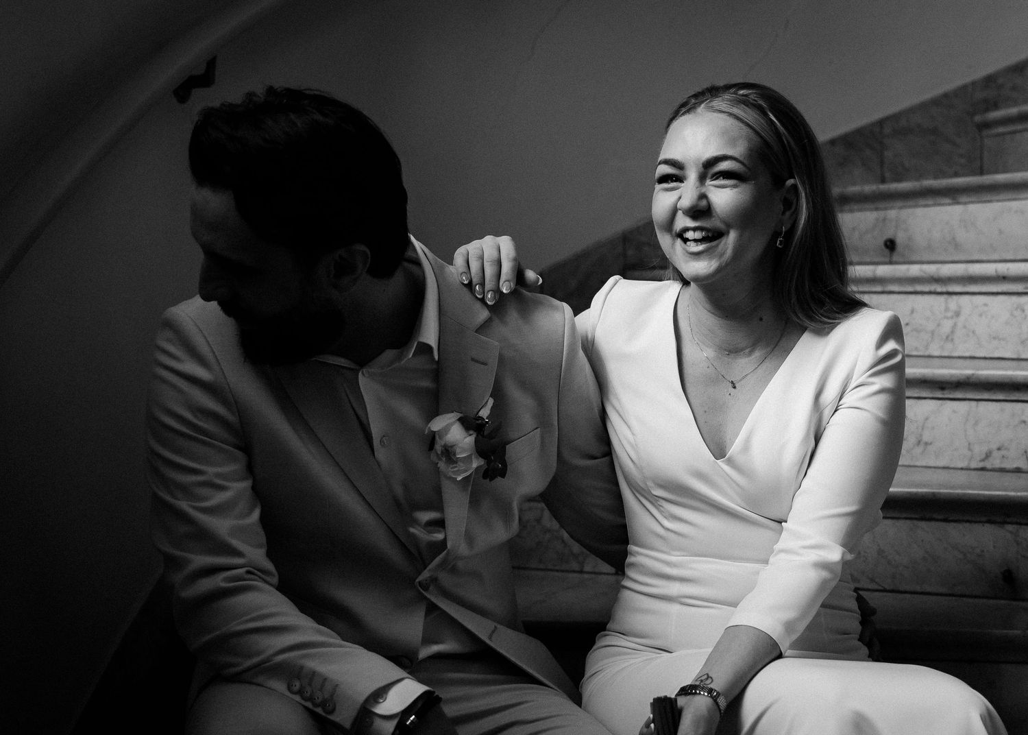 Black and white photos capture tender moments between a couple on elegant stairs.