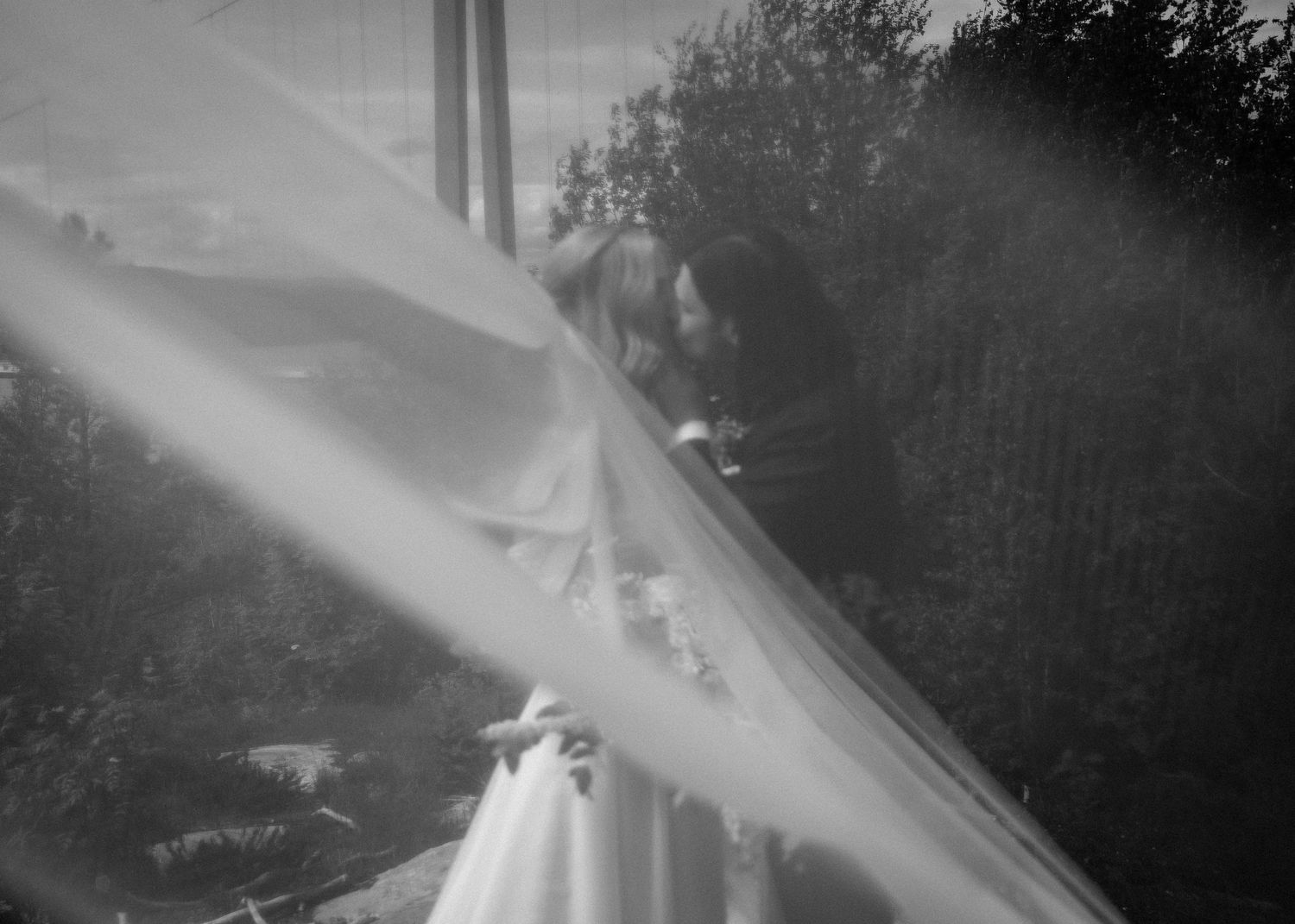 Ethereal black and white photo showing flowing white fabric against a dark background.