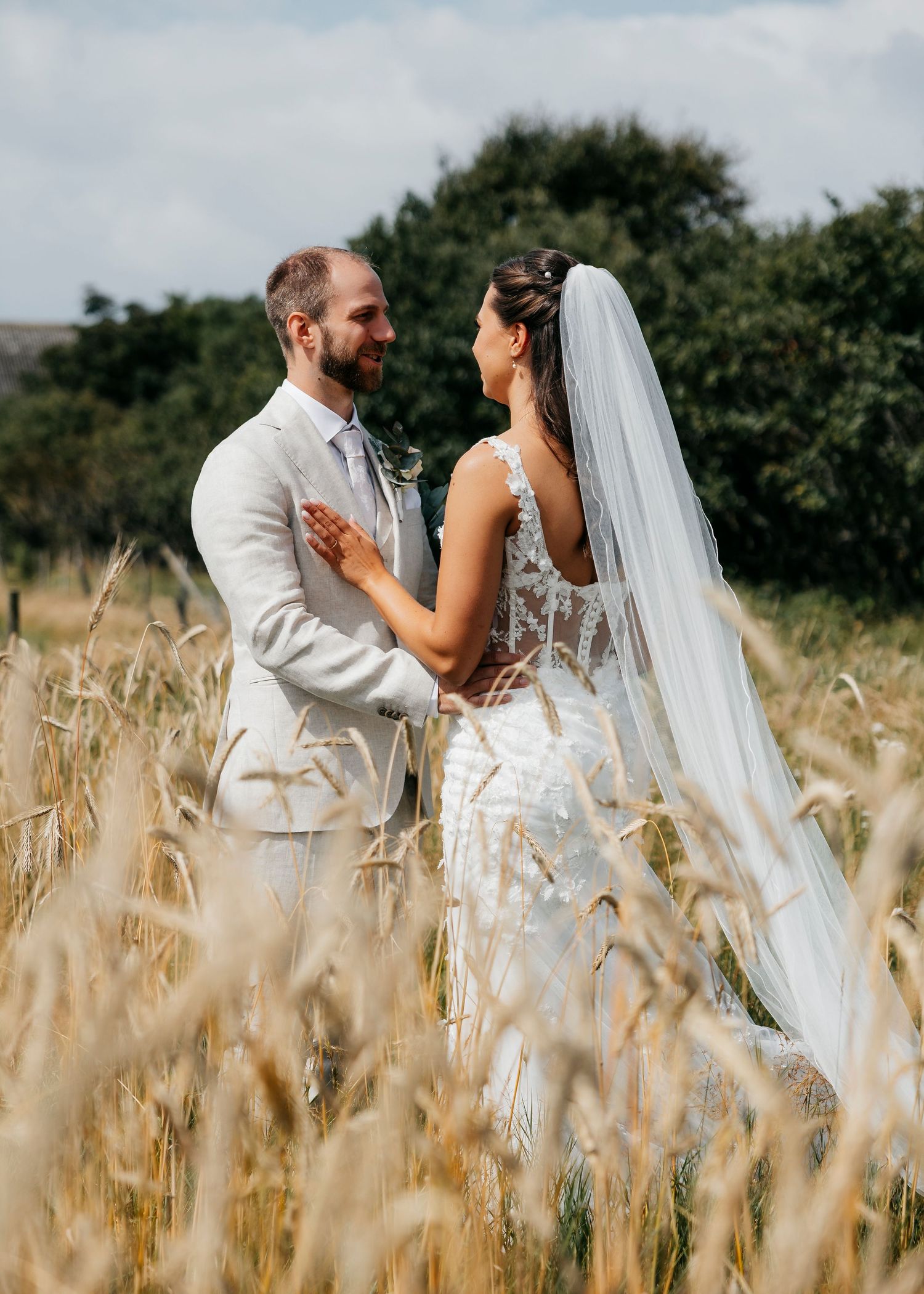 Romantic wedding portraits captured in a sun-lit wheat field.