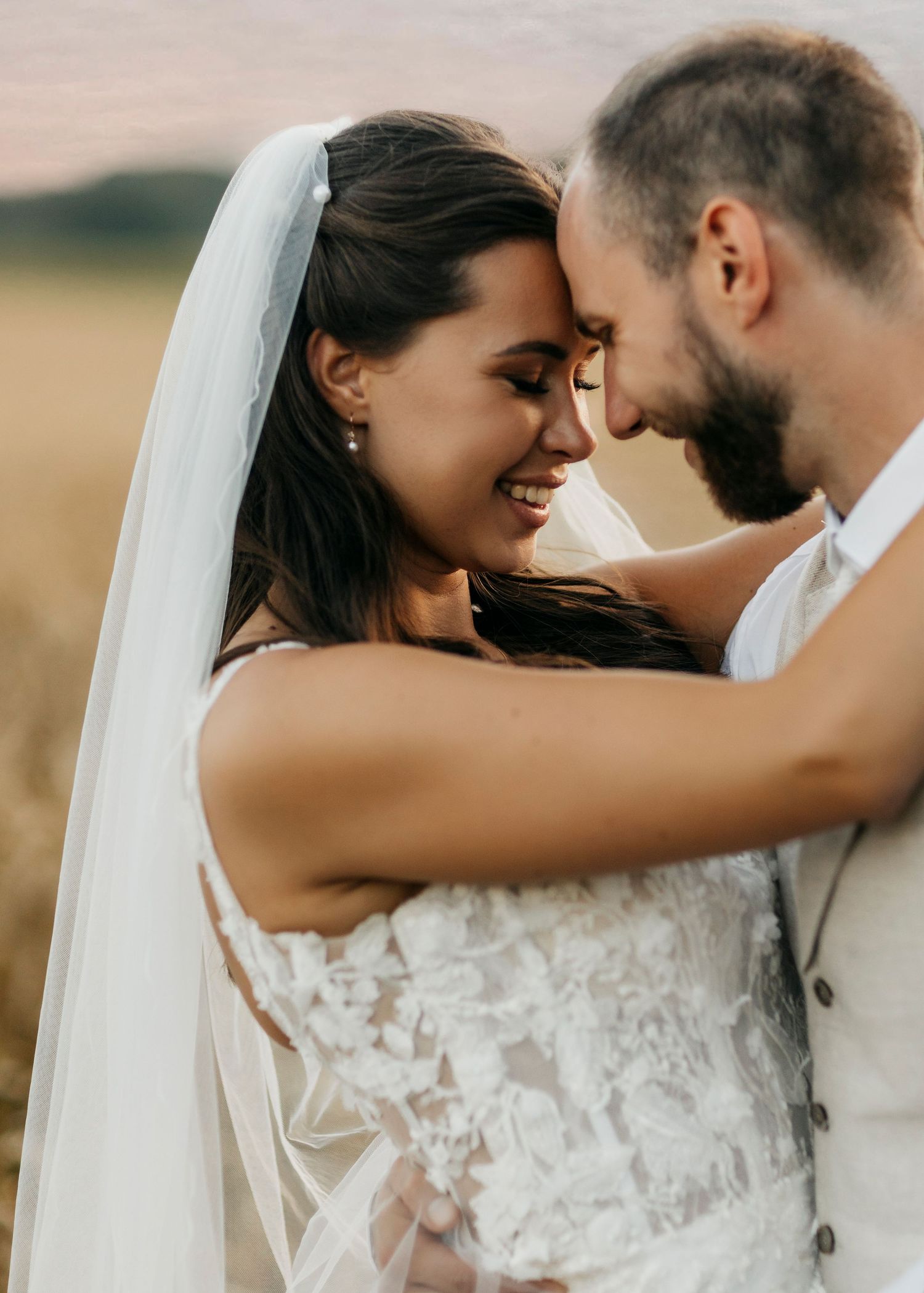 Intimate wedding couple portraits in a field during golden hour.