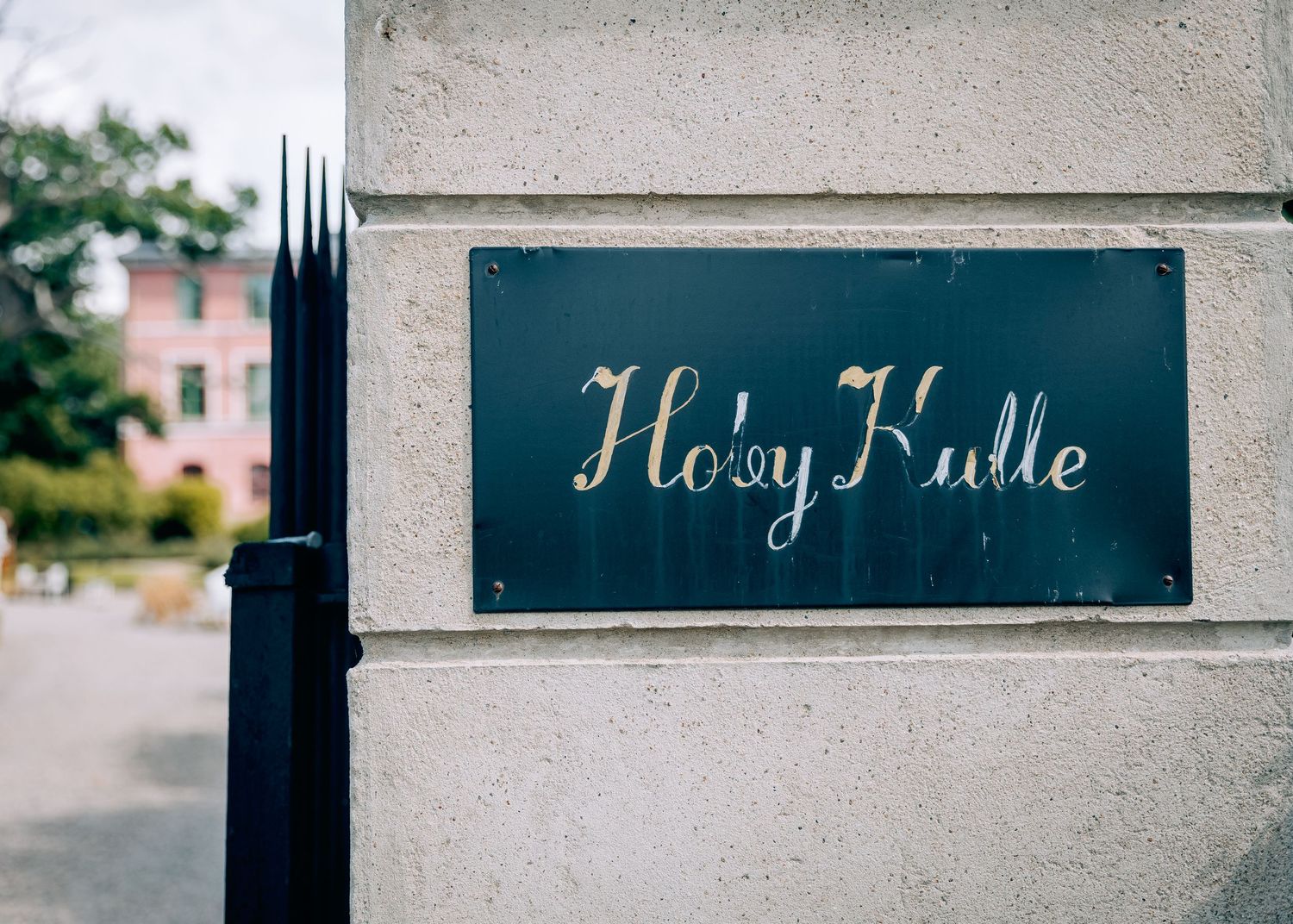 Vintage style signage mounted on concrete wall with elegant script lettering.