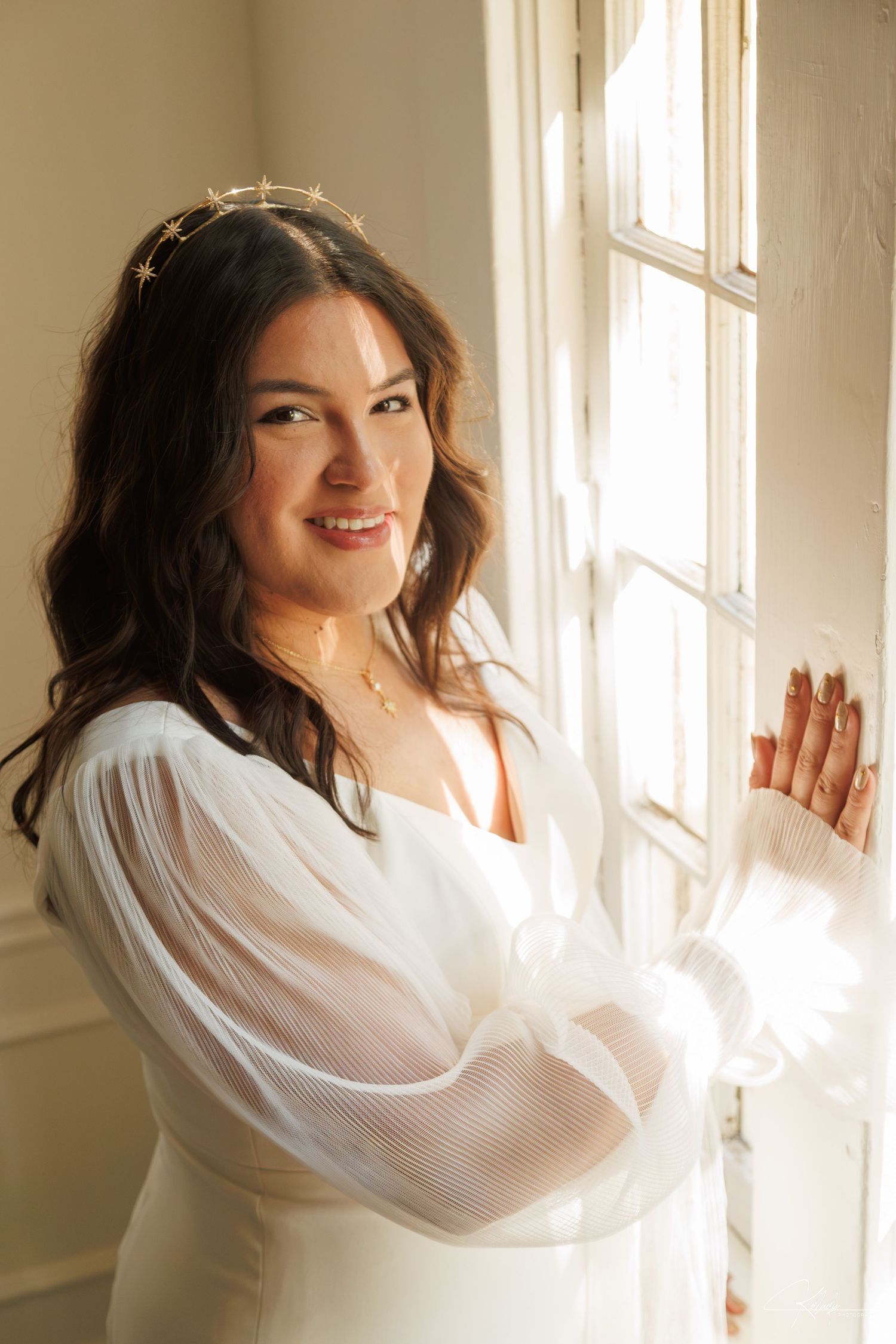 Bride posing beside a window in an elegant white gown, photographed by KDLADYPHOTOGRAPHY LLC in Atlanta, GA.