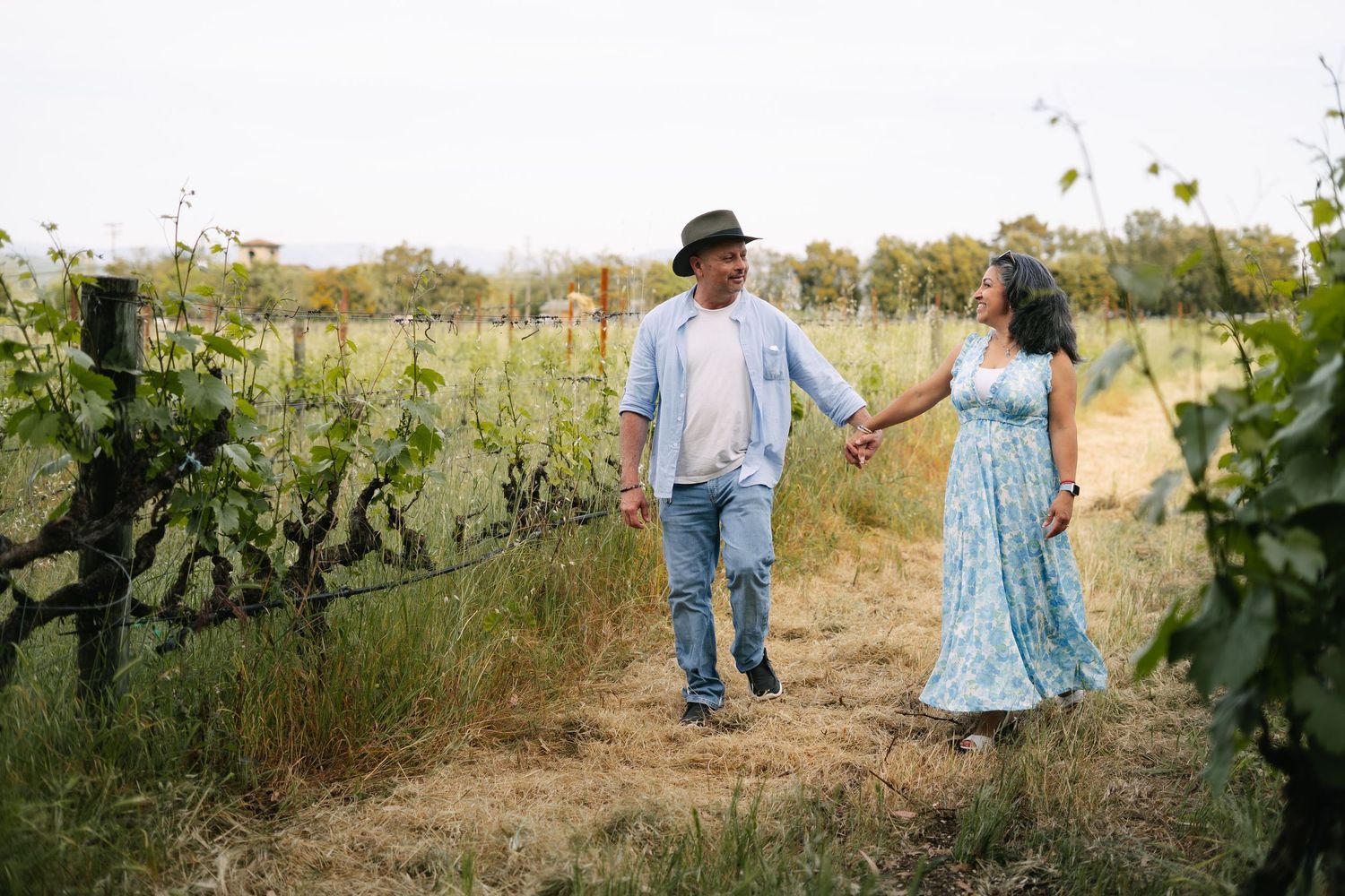 couple holding hands in vineyard