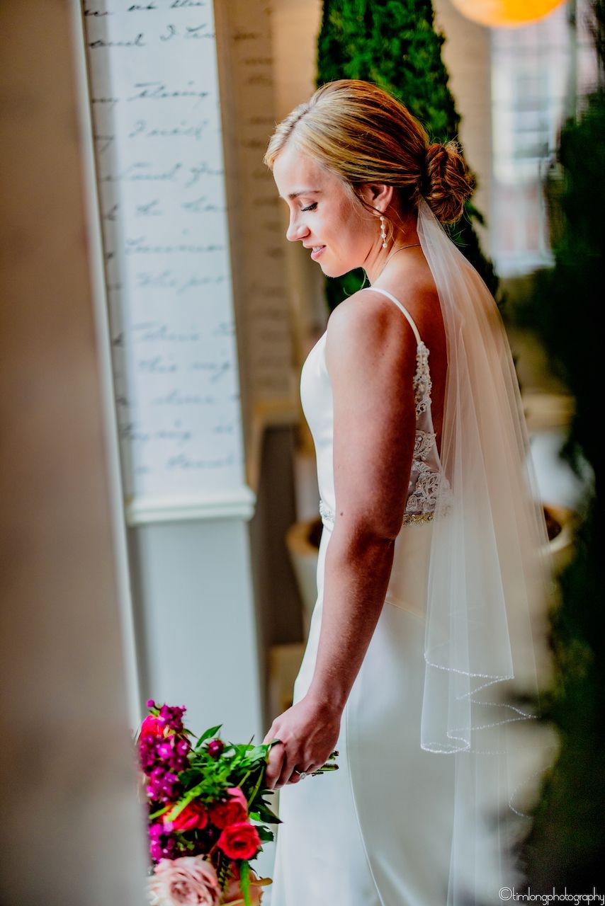 Elegant bridal portraits featuring white gown and vibrant pink bouquet.