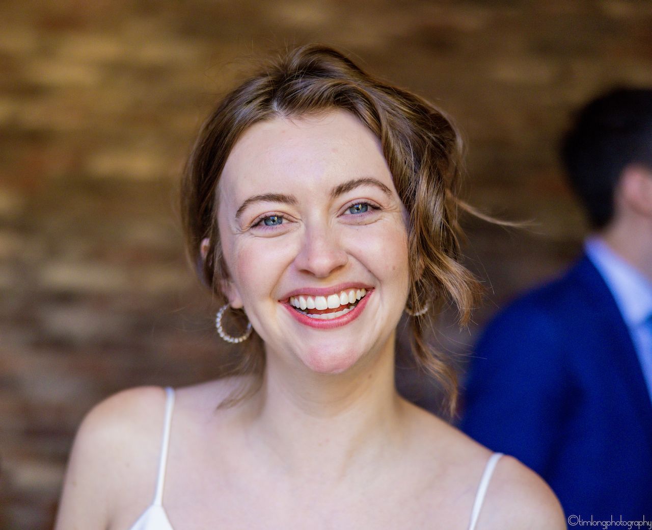 Close-up portraits showing joyful expressions against a stone wall background.