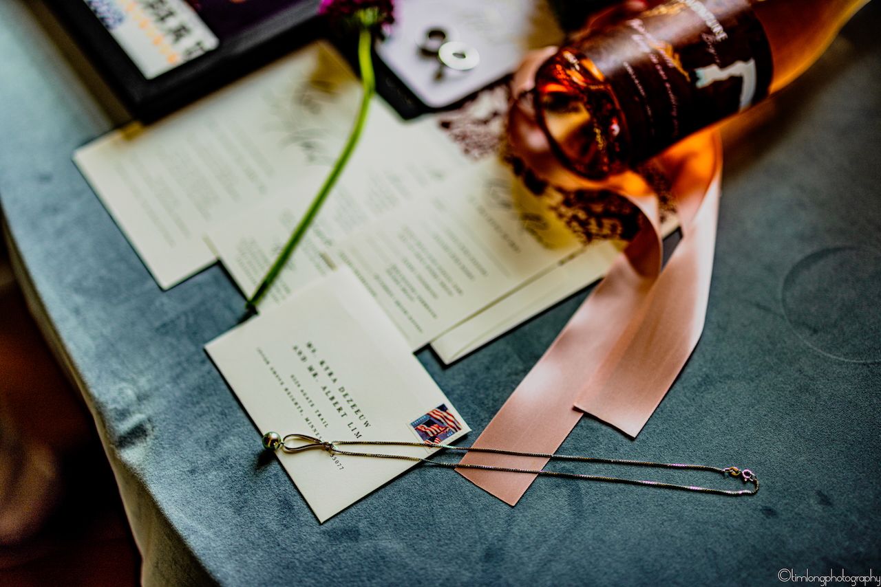 Close-up details of wedding stationery and invitation materials on dark surface.