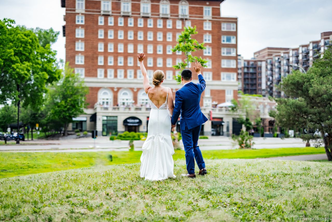Wedding couple portraits on lawn with red brick building in background.