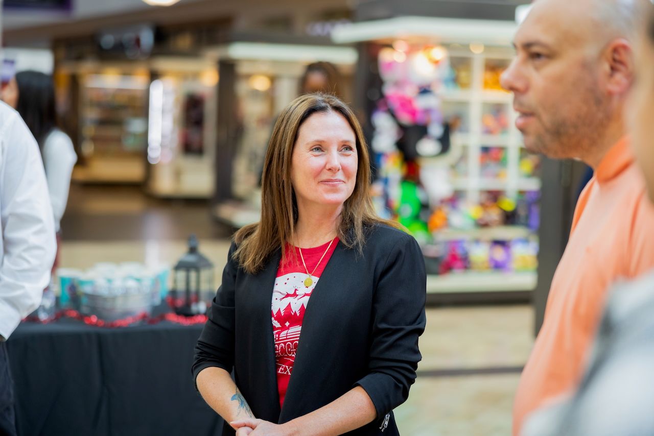 Small group gathered for discussion or meeting in a retail shopping environment.
