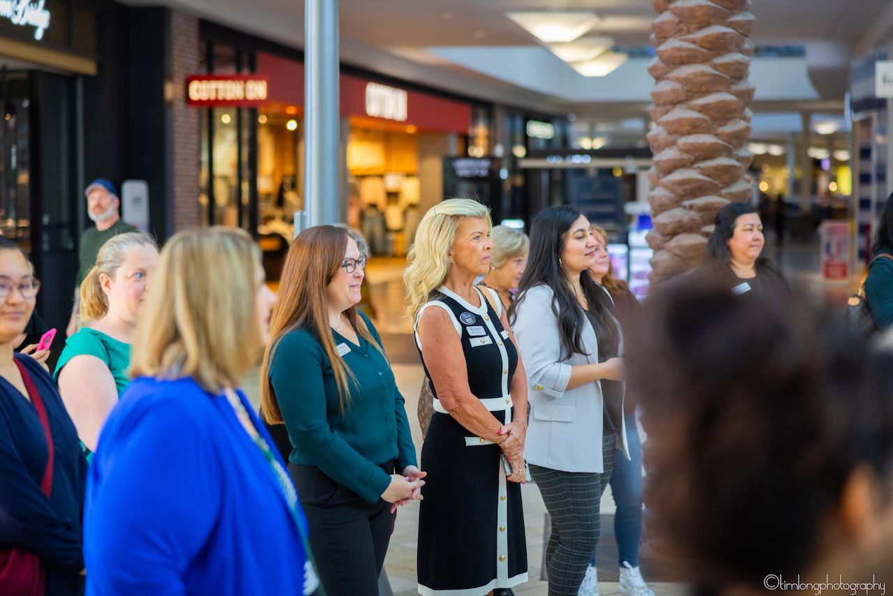 People gathered in a shopping mall corridor for a special event or celebration.