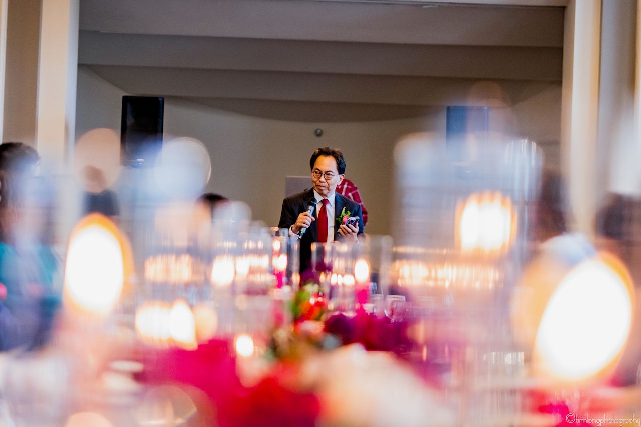 Romantic wedding reception venue with blue uplighting and chandeliers creating an elegant ambiance.