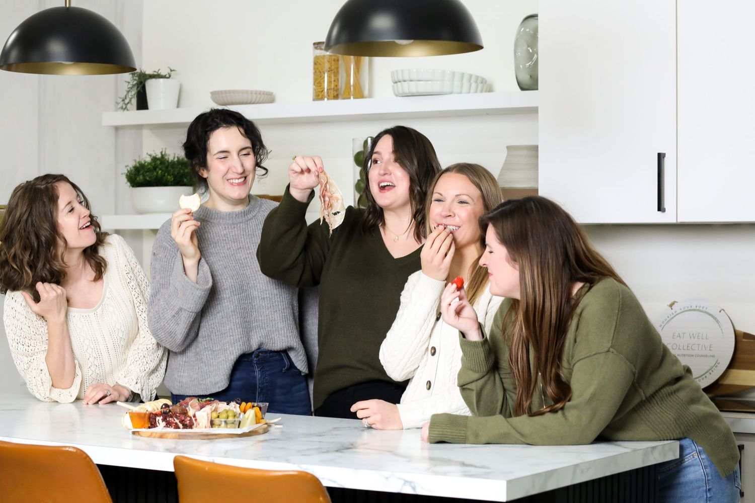 Four images showing people collaborating in a bright modern workspace with white tables and bookshelves.