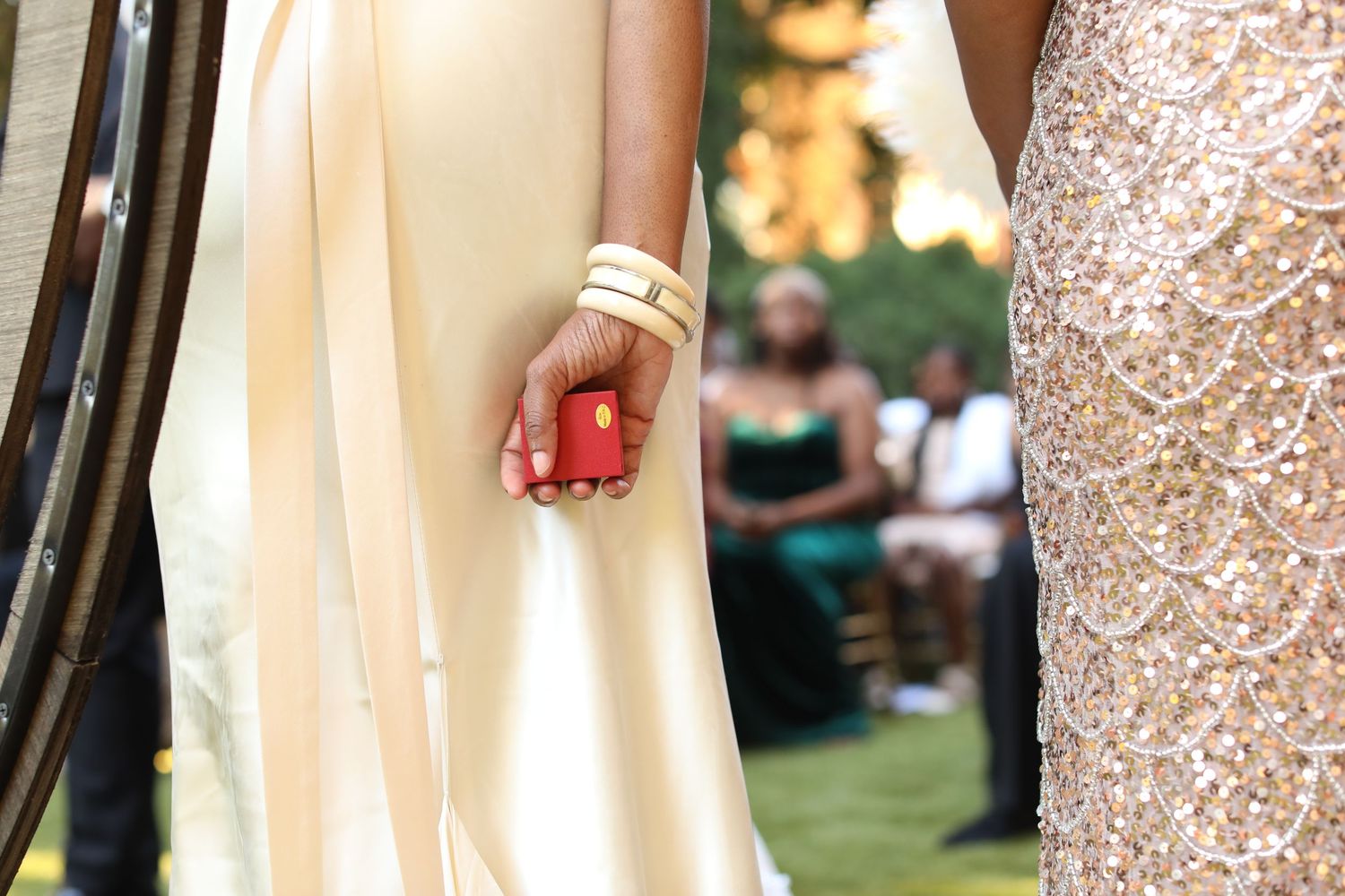 Bridesmaids in champagne sequin dresses standing together at outdoor ceremony.