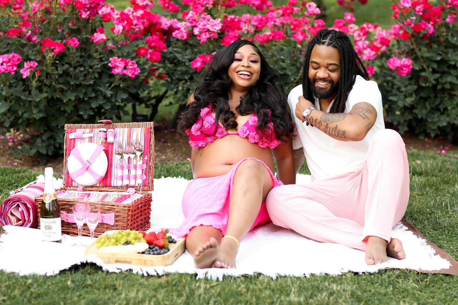 Romantic garden picnic setup with pink decor and bright flowers.