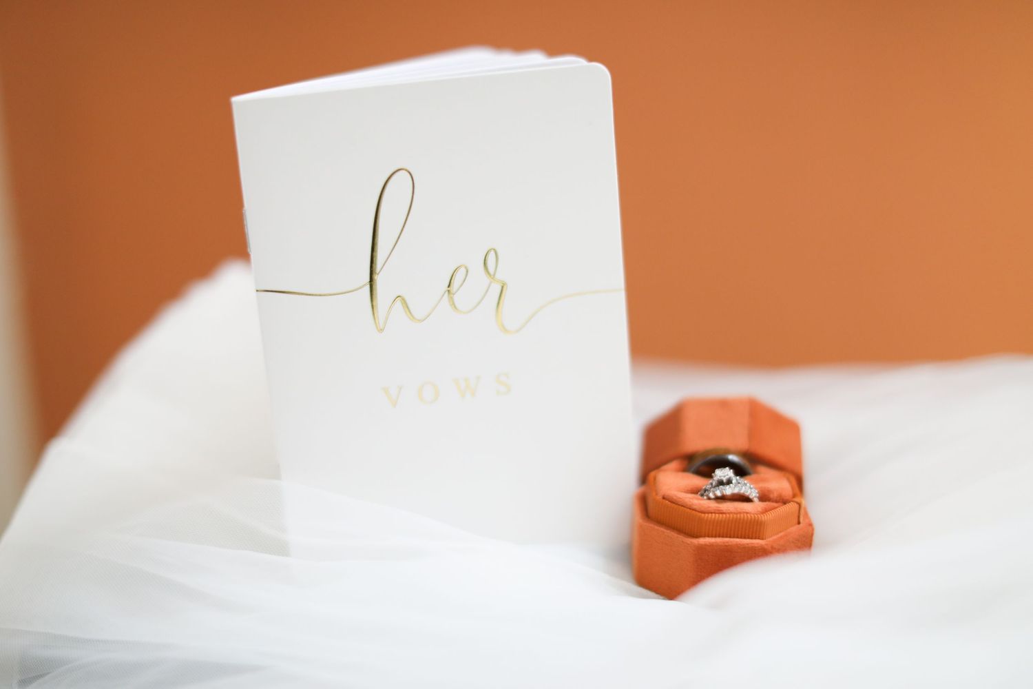 Wedding rings displayed on white cards with elegant gold lettering.
