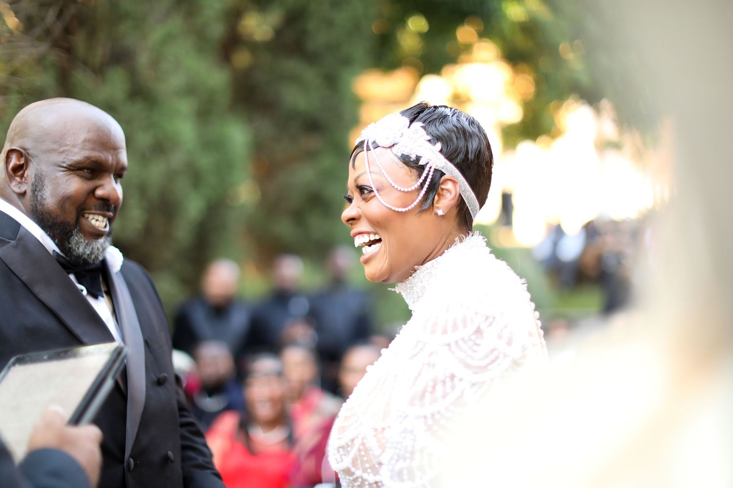 Happy couple shares a laugh during outdoor wedding ceremony.