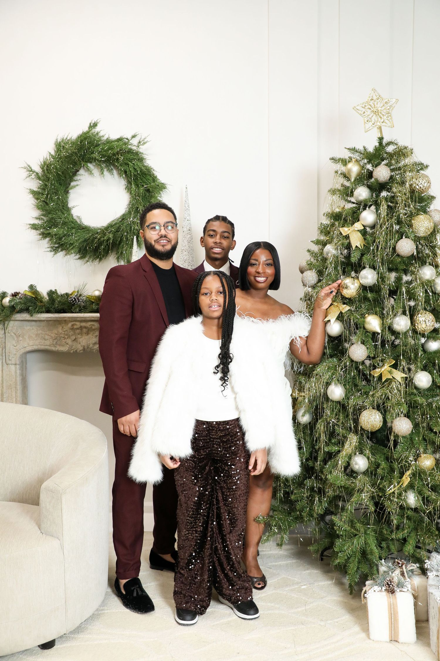 Holiday family portrait with Christmas decor and white floral arrangements.