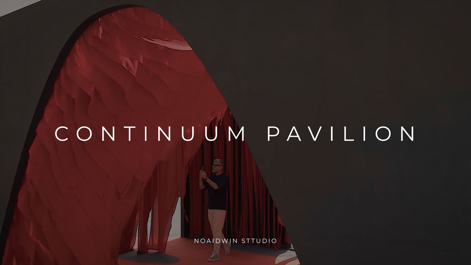 A person stands inside the Continuum Pavilion, a striking red sculptural arch installation by Nordinin Studio.