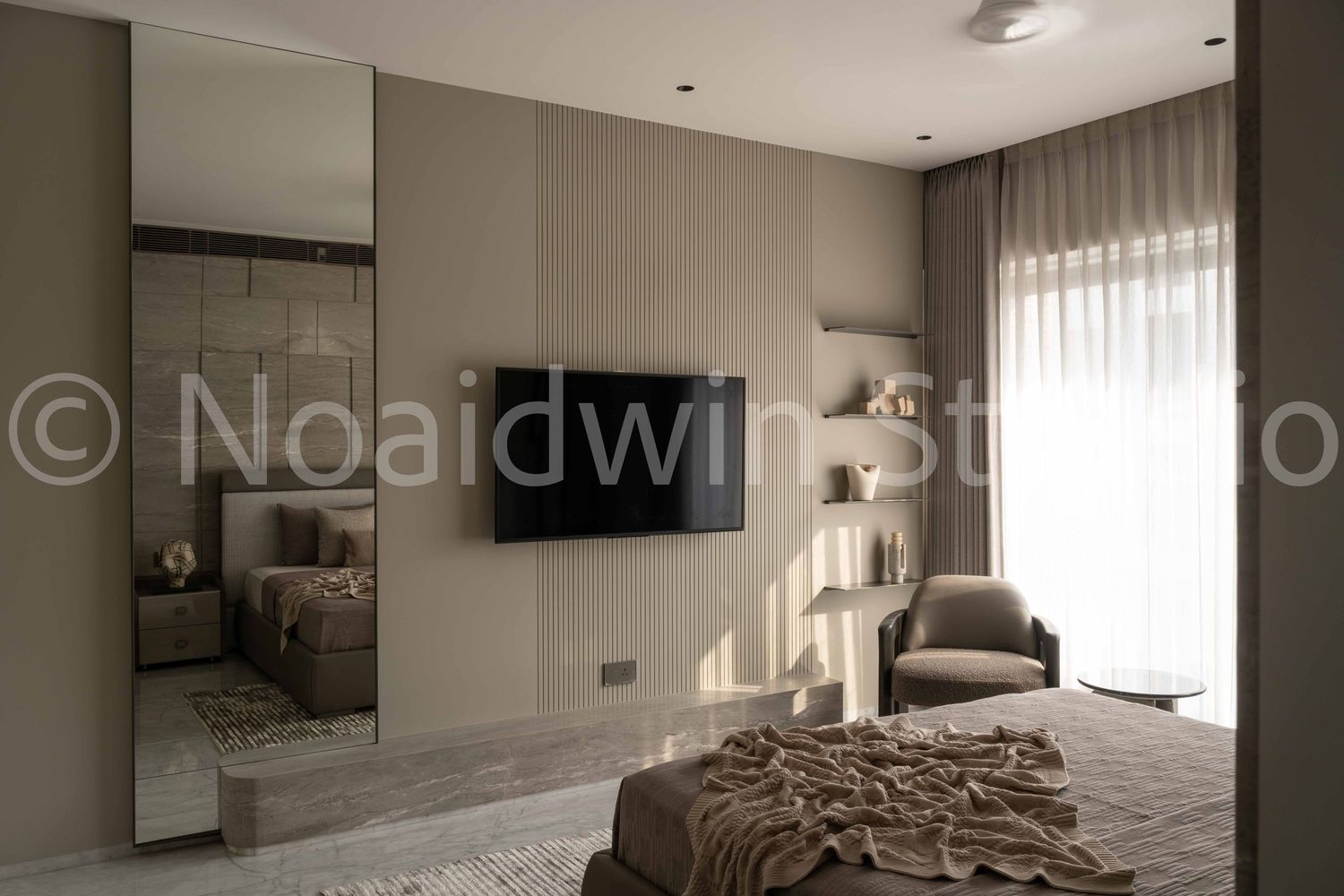 Contemporary bedroom with mirrored wardrobe, wall-mounted TV, fluted panel wall, and sheer curtains.