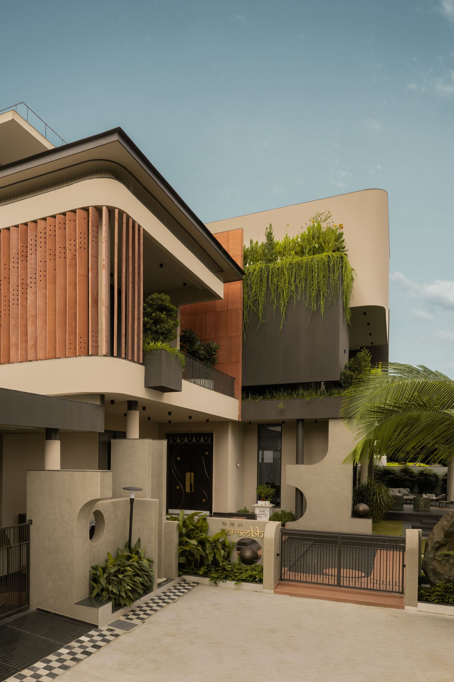 Modern two-story home with wooden louvers, lush vertical gardens, and contemporary architecture under a clear blue sky.