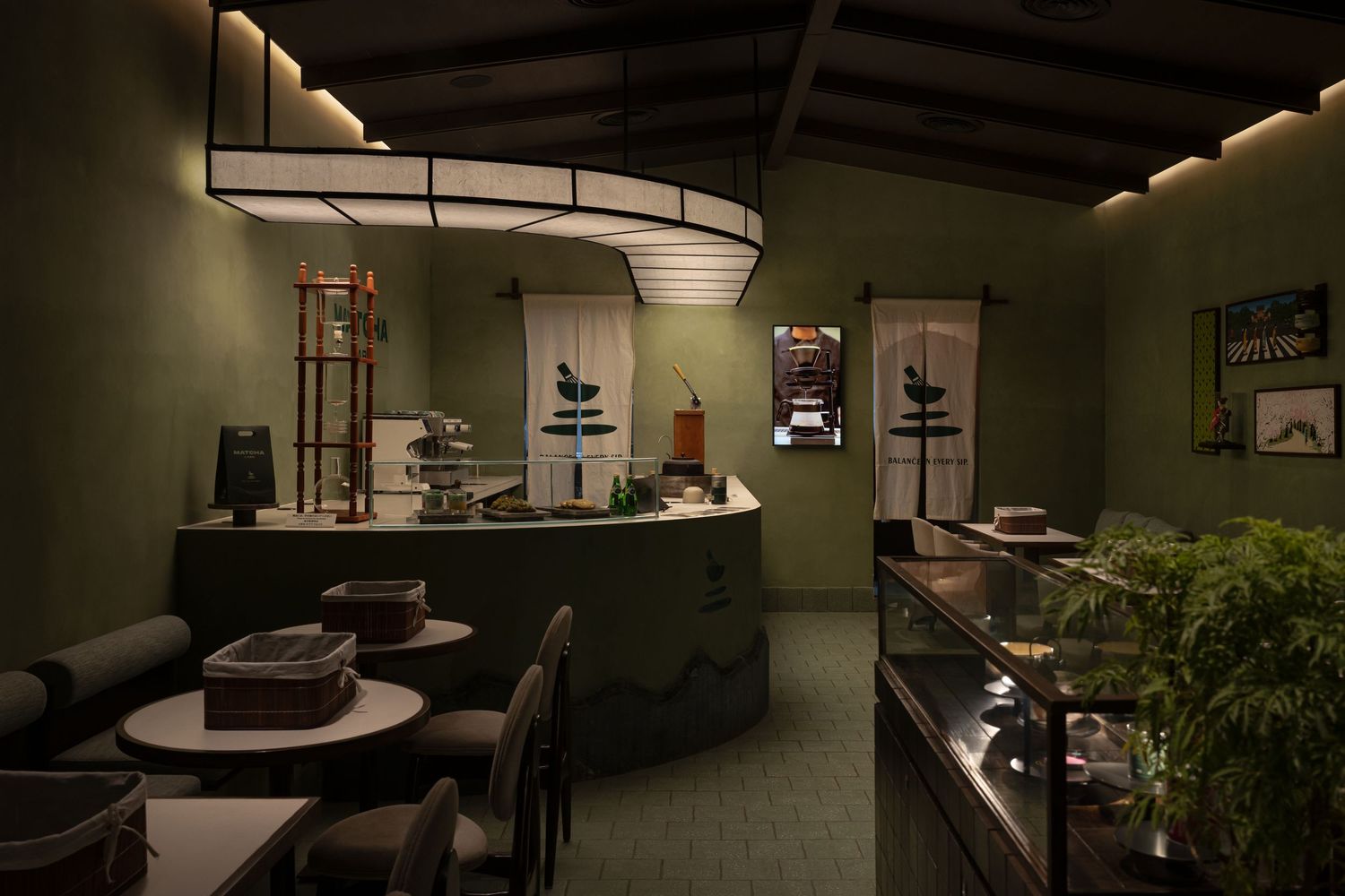 Dimly lit matcha bar with curved green counter, ambient lighting, and Japanese-inspired interior design.