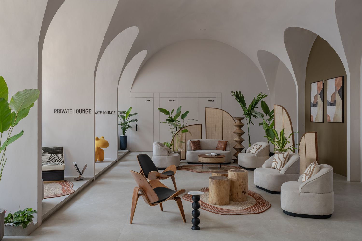 Airy private lounge featuring vaulted arched ceilings, eclectic seating, tropical plants, and warm neutral tones.