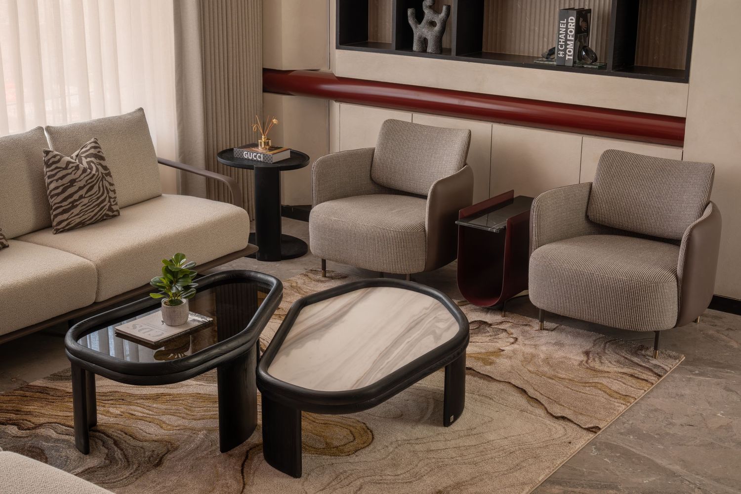 Luxury seating area with gray armchairs, black marble coffee table, and patterned area rug.