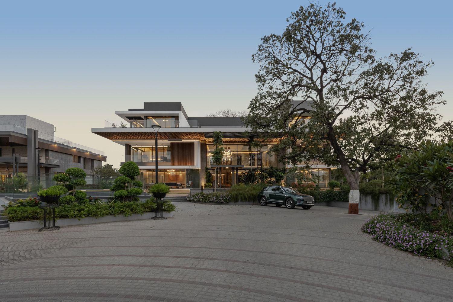 Elegant low-rise building with Japanese-inspired landscaping, paved driveway, and mature trees.