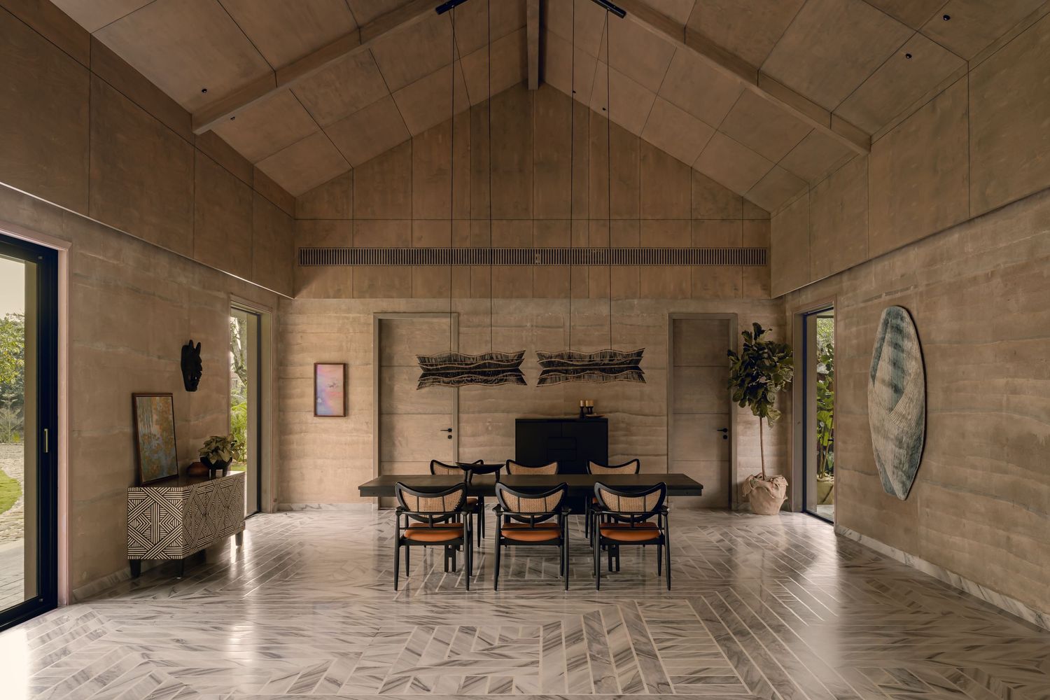 Vaulted ceiling dining room with stone walls, patterned marble floors, and wooden furniture.