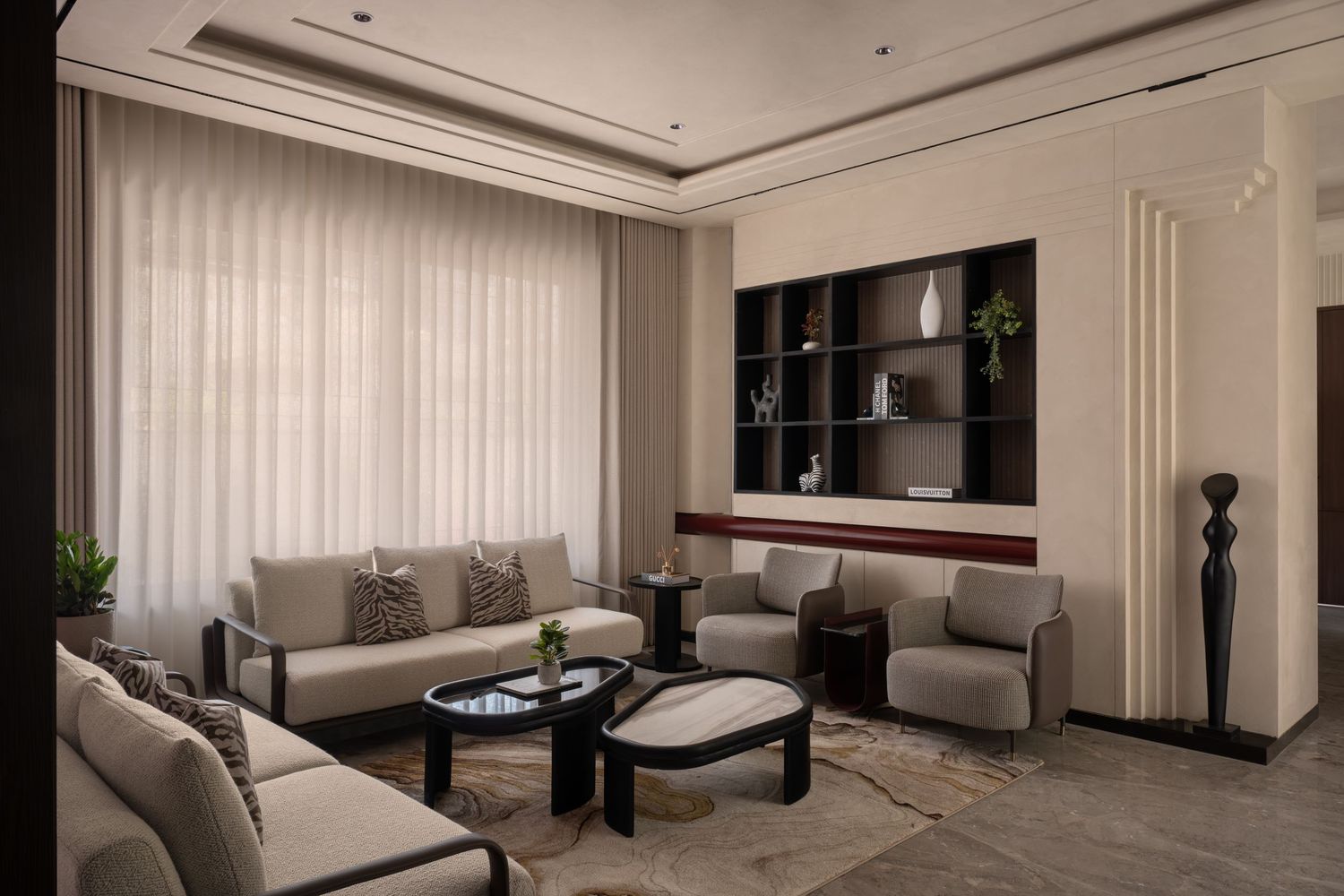 Elegant living room with beige sofas, dark shelving unit, sheer curtains, and neutral decor.