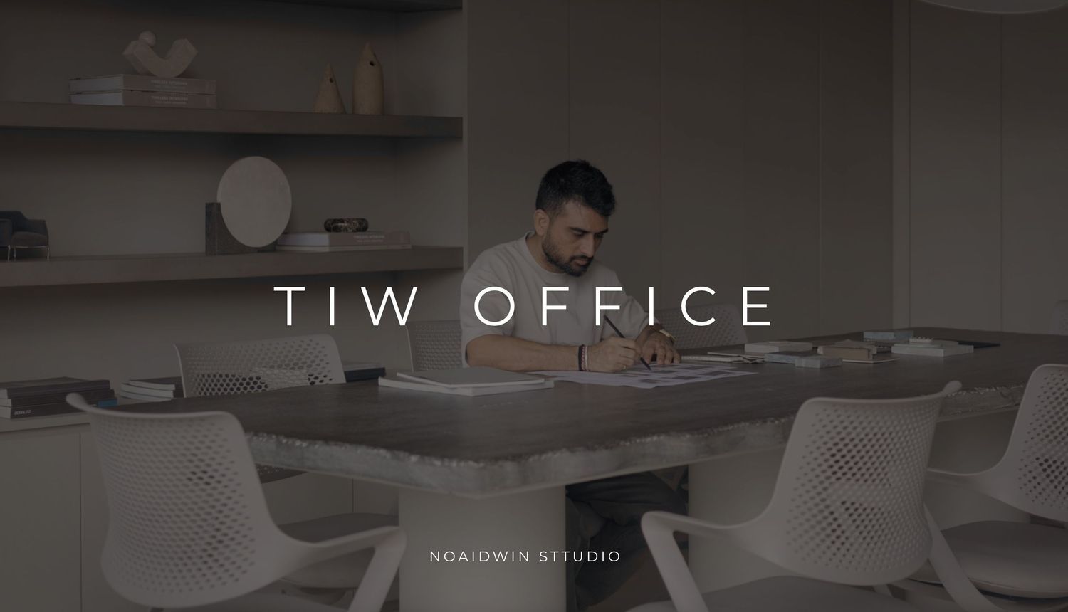 A man works at a modern office desk in a minimalist workspace, featured in Noaidwin Studio's TIW Office design.