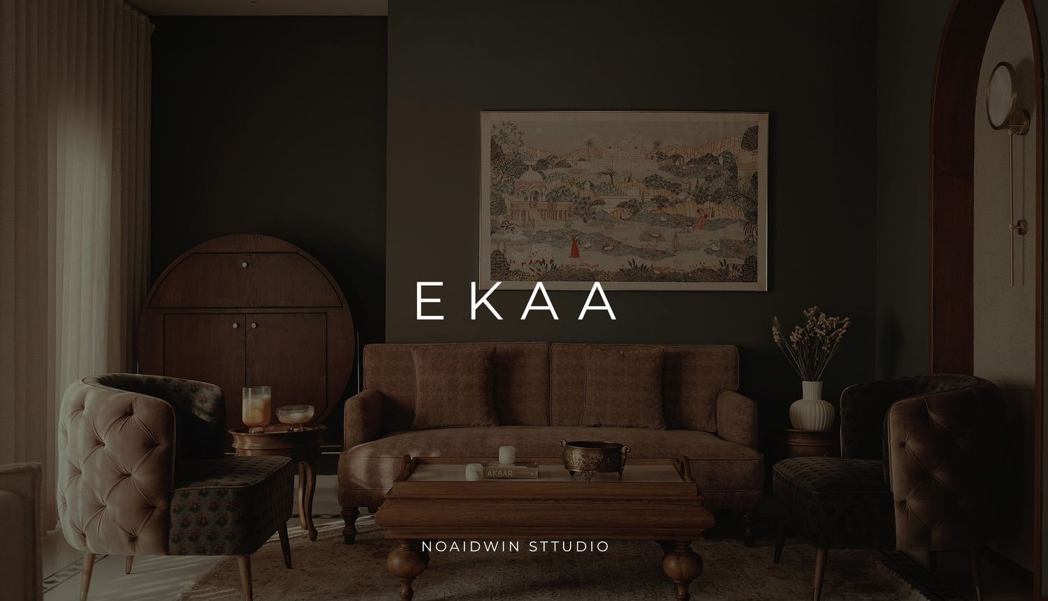 Ekaa luxury interior design studio showcasing elegant brown velvet sofas, warm lighting, and sophisticated dark-toned living room decor.