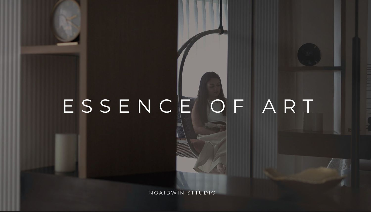 Essence of Art interior design studio promotional image featuring a person sitting in a modern, elegantly lit room.