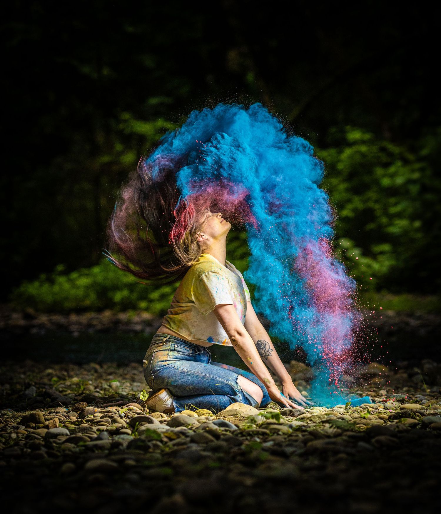 Artistic photo with blue and pink powder paint explosion against dark background.