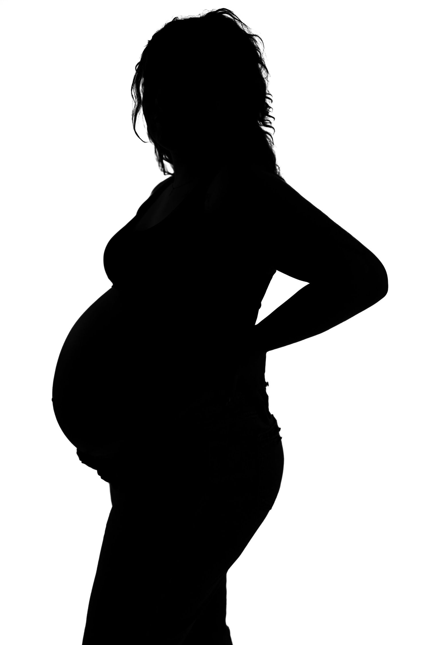 Black and white silhouette of a pregnant woman standing in profile with hand on hip.
