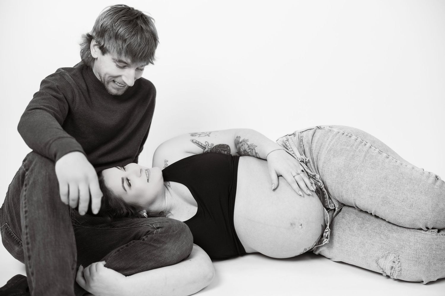 Two people lying down in a series of tender black and white photographs.