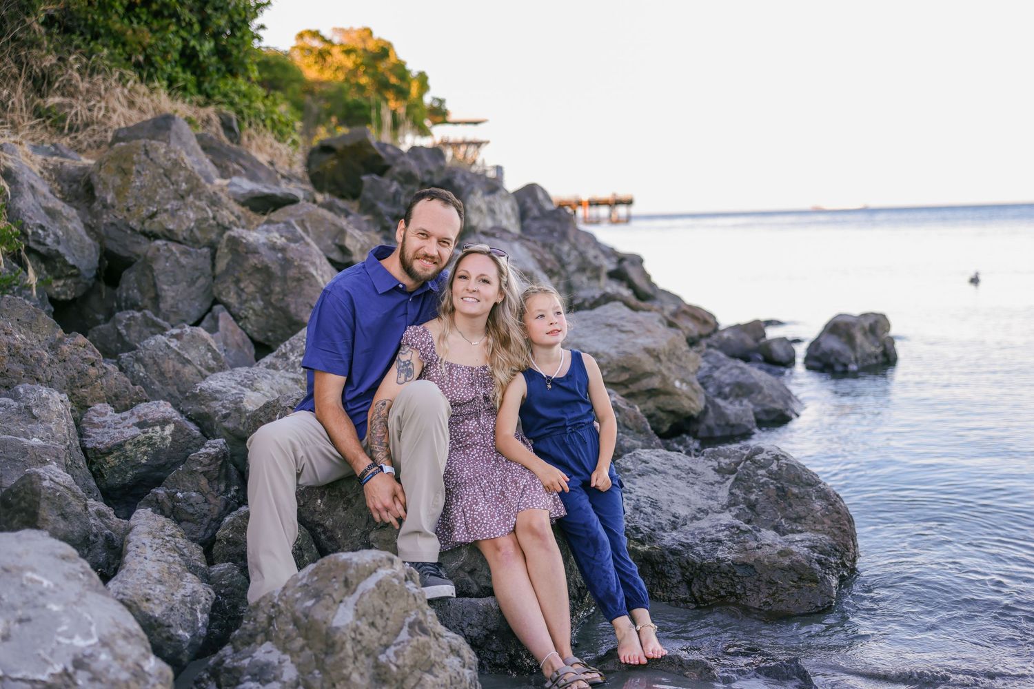 Family enjoying quality time together on a rocky beach with ocean views.
