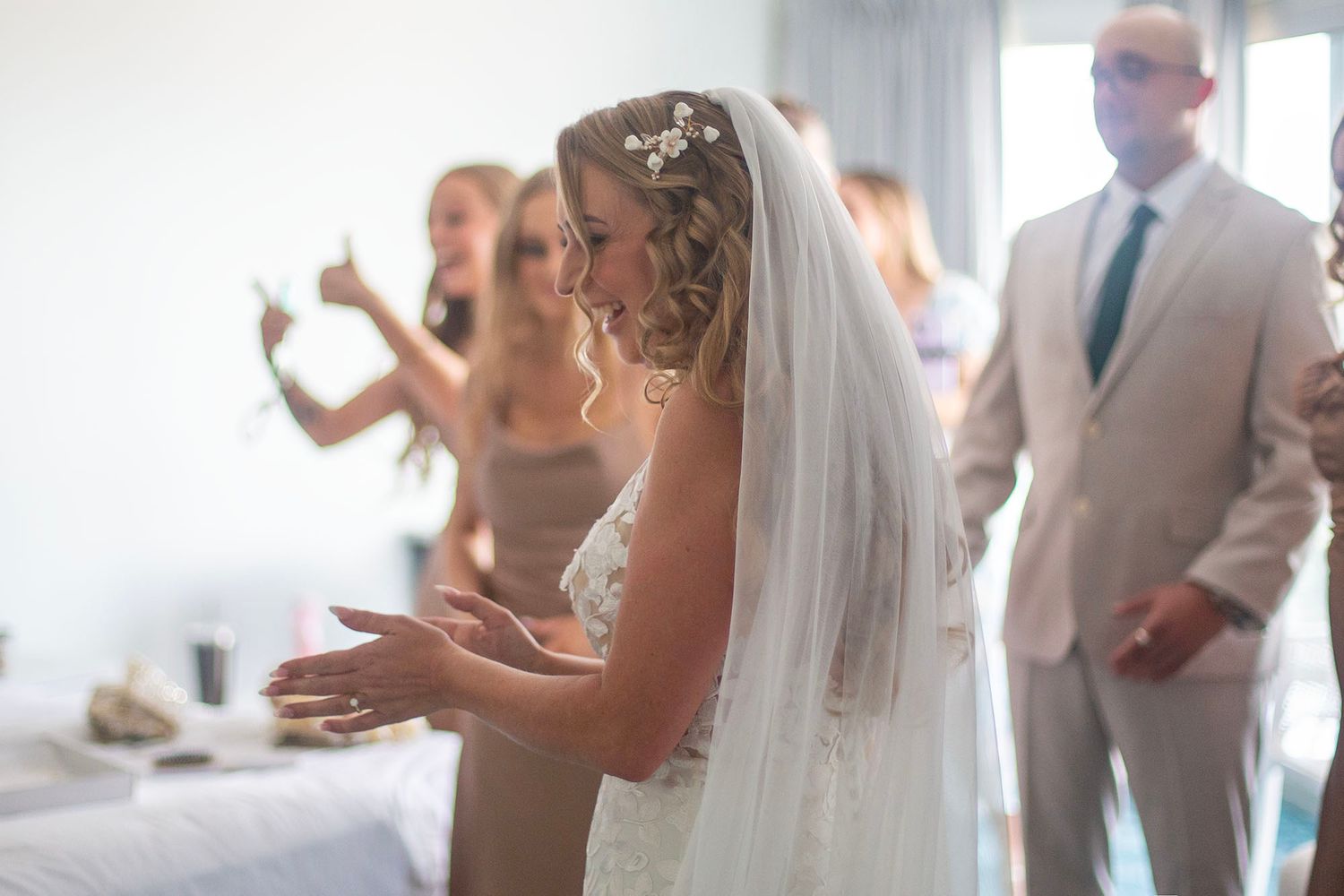 Wedding party members experiencing an emotional moment in a sunlit room.