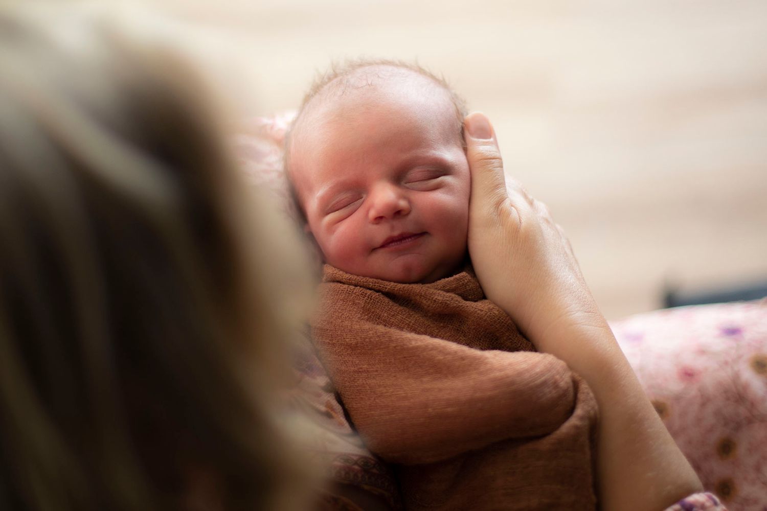 Close up photo of sleeping newborn baby with soft blurred background creating dreamy atmosphere.