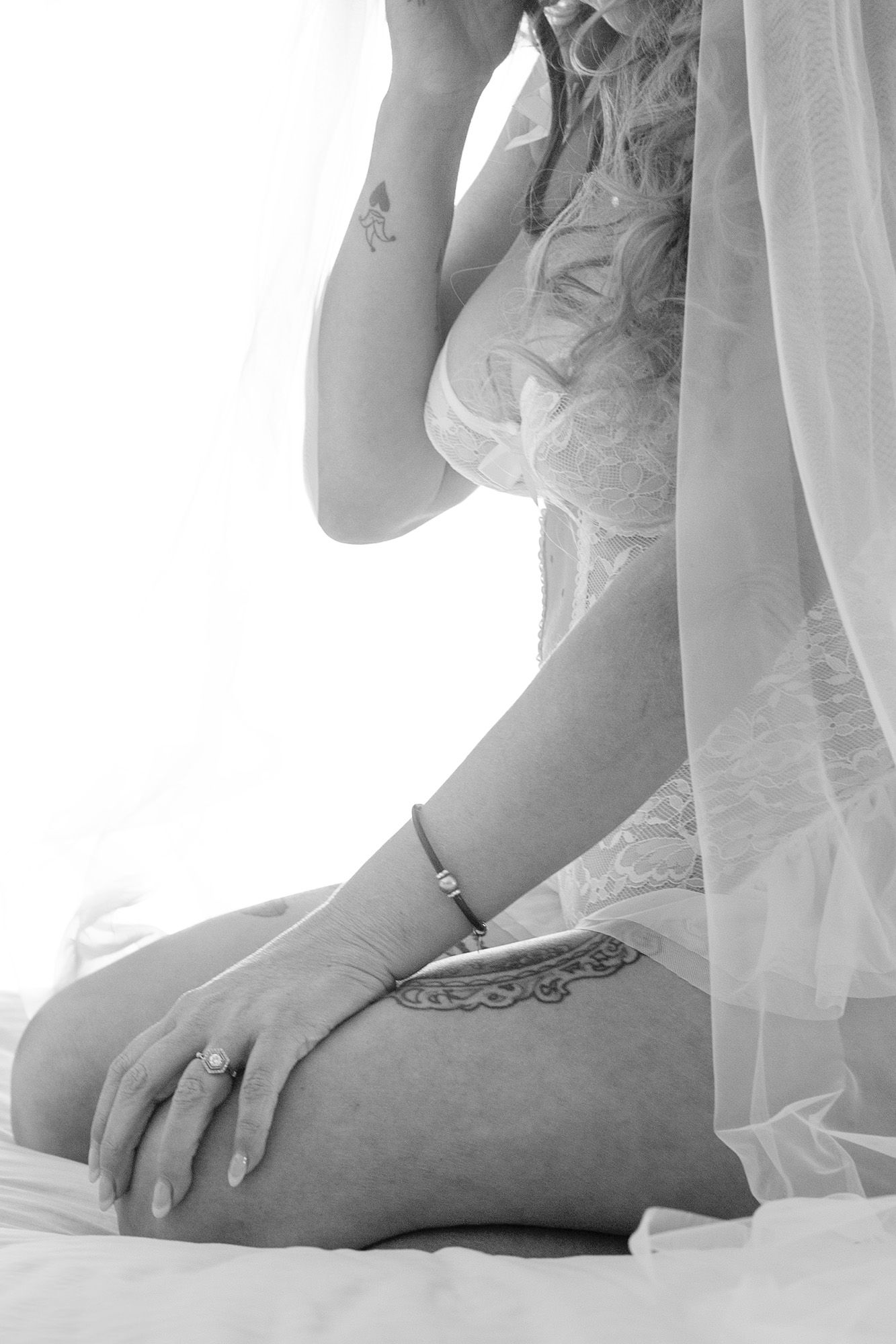 Artistic bridal boudoir photo with soft white lace and delicate details.
