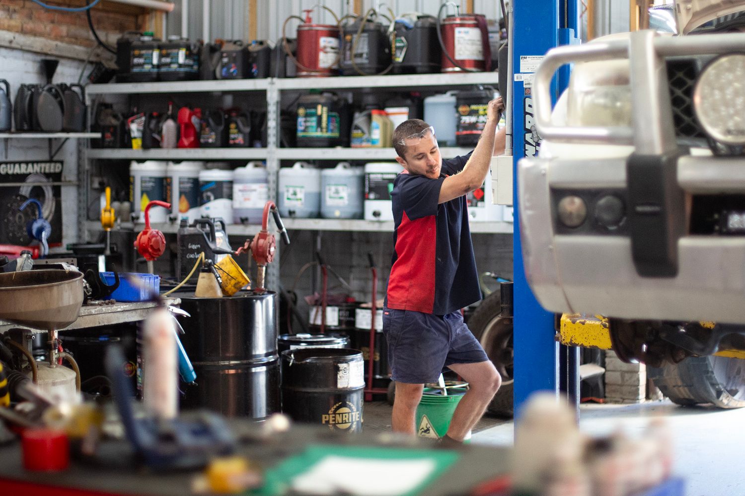 Auto parts and tools organized on industrial shelving in repair shop.