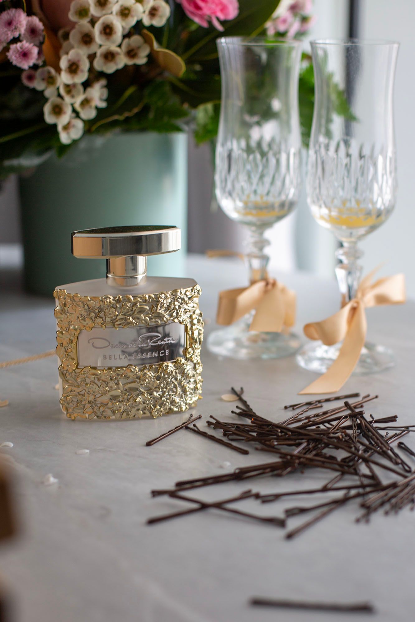 Wedding table setting with gold accents, crystal glasses and scattered bobby pins.