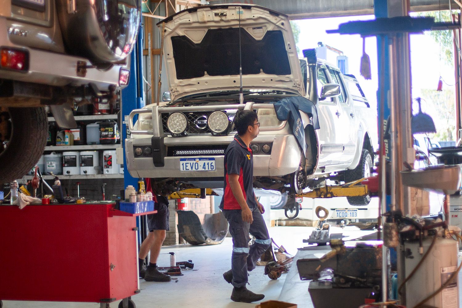 Auto repair shop interior showing multiple vehicle lifts and equipment.