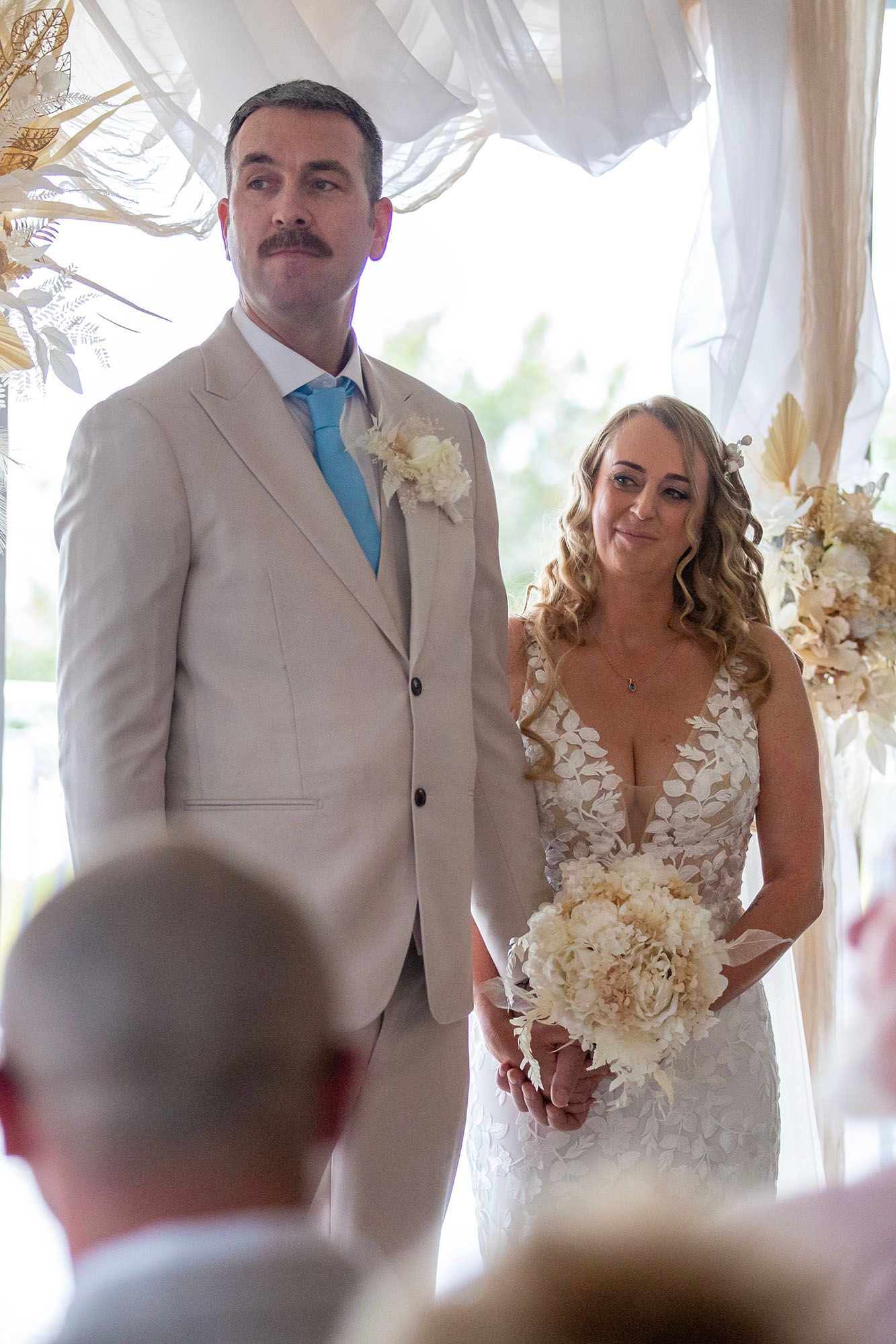 An emotional wedding ceremony moment captured in a light-filled venue.