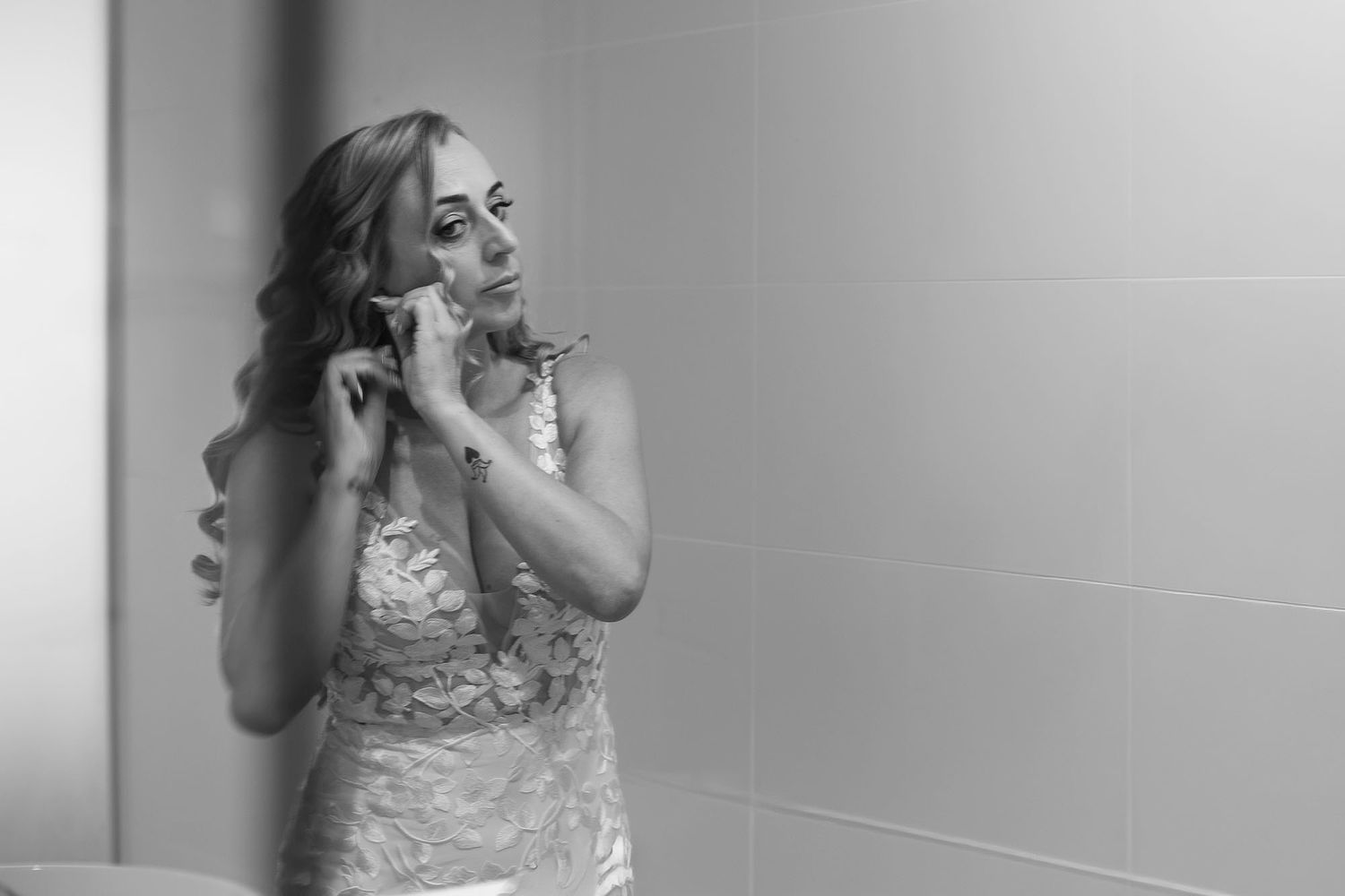 Candid black and white preparation moment in a bright room.