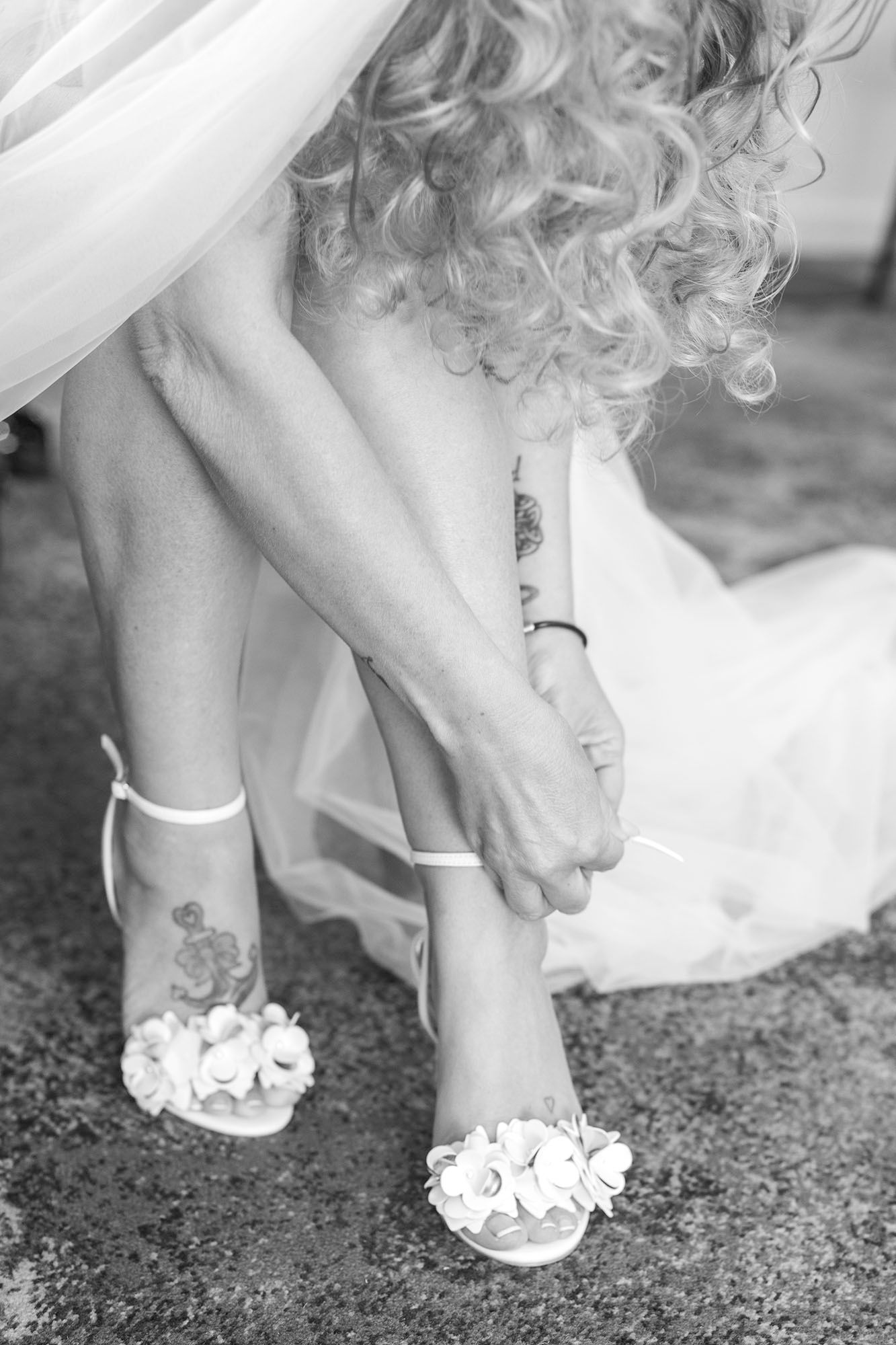 Series of detailed shots showing elegant white bridal shoes with floral embellishments on carpet.