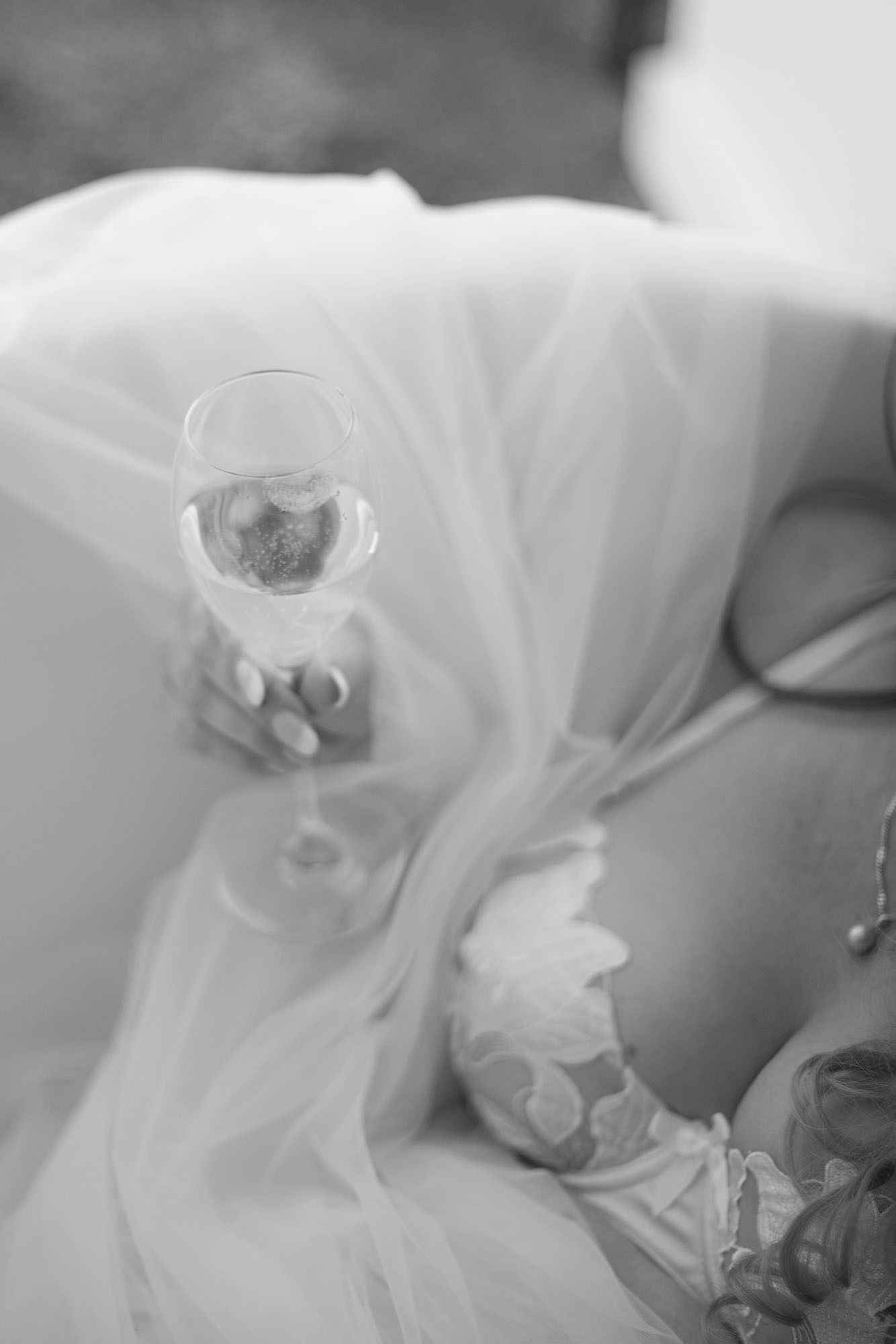 Black and white wedding detail shots showing champagne glasses and flowing fabric.