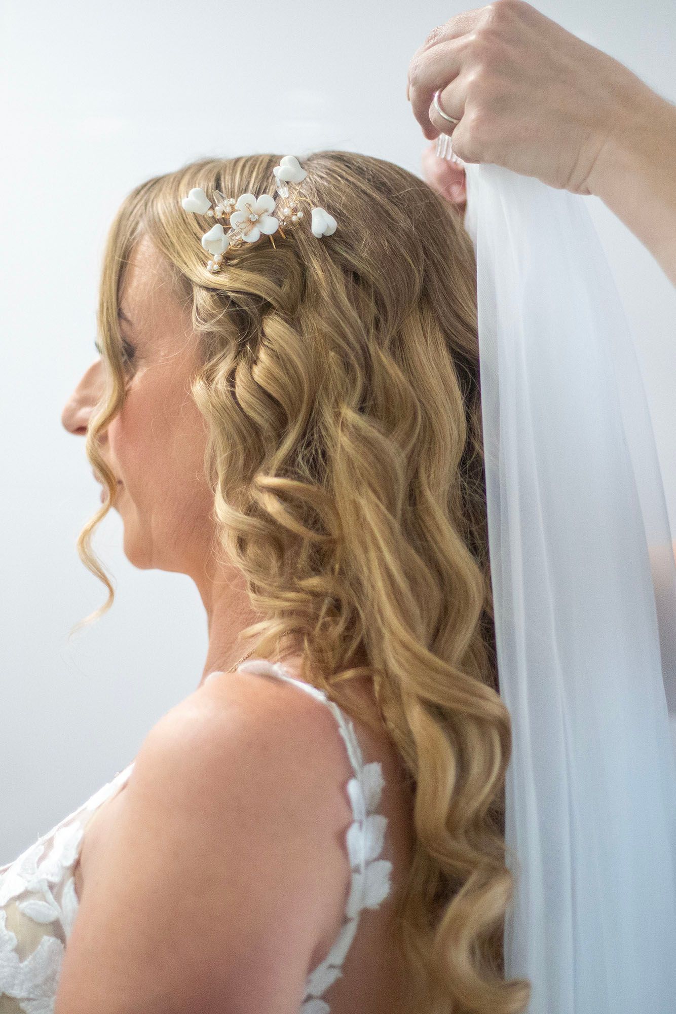 Wedding preparation shots showing veil and hair accessories in soft natural light.