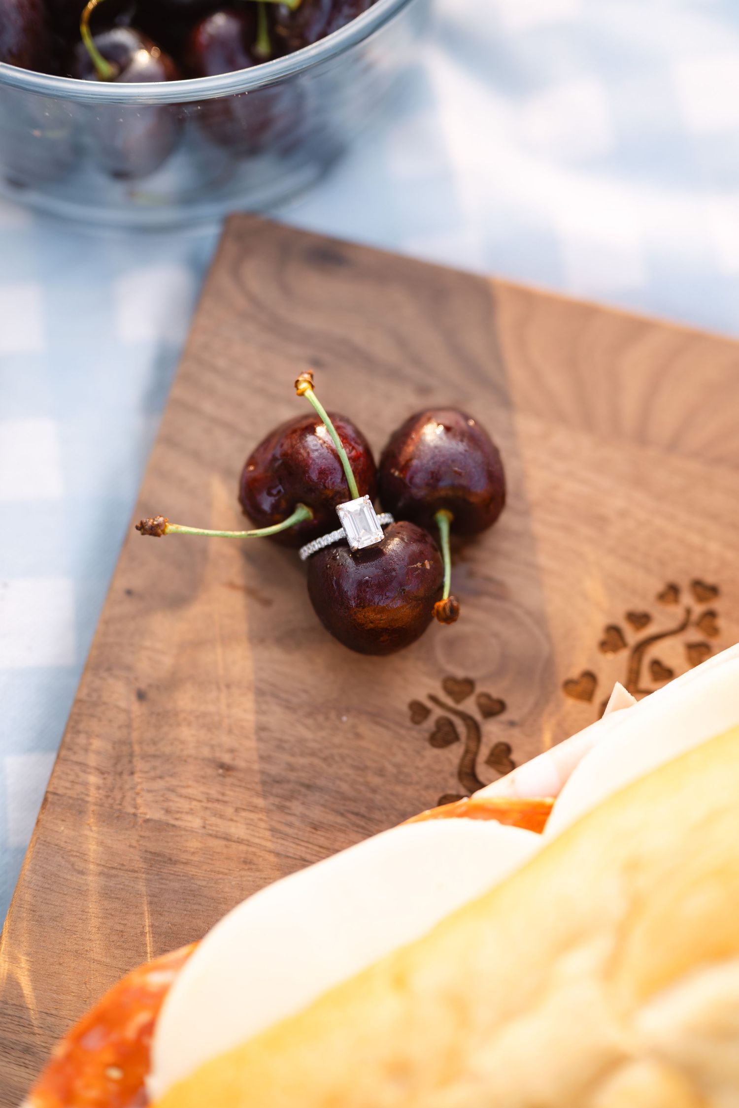 Fresh cherries and cantaloupe arranged on a wooden cutting board.